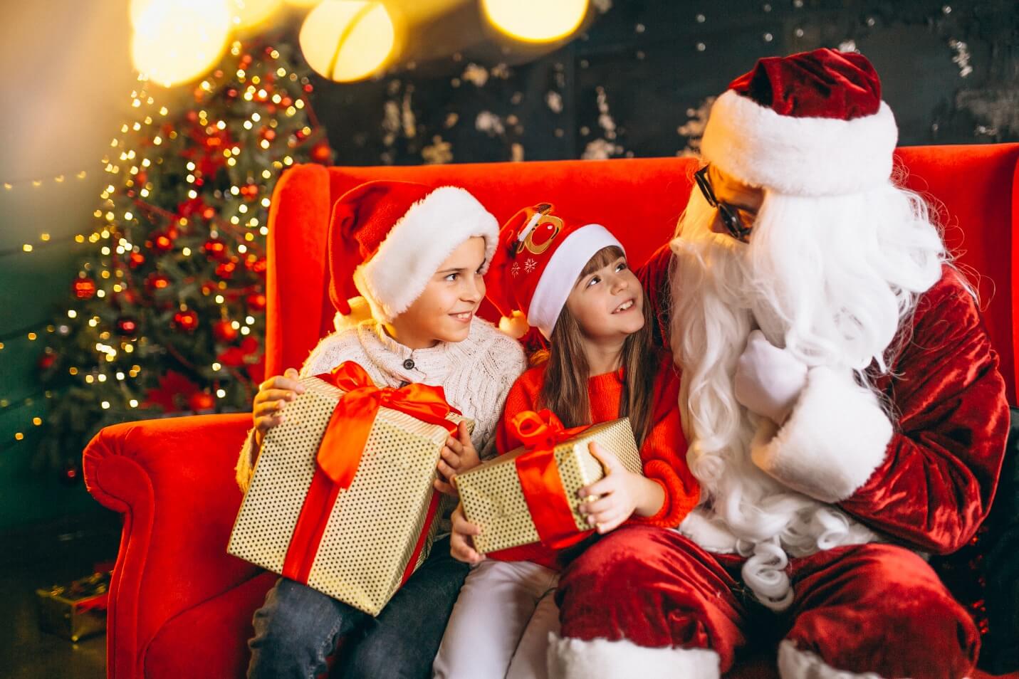 Santa talking to two kids sitting on a chair