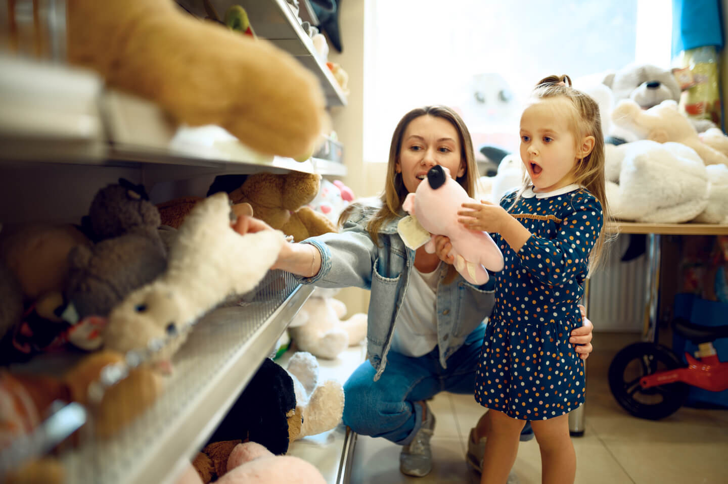 Mom and little girl choosing soft toys