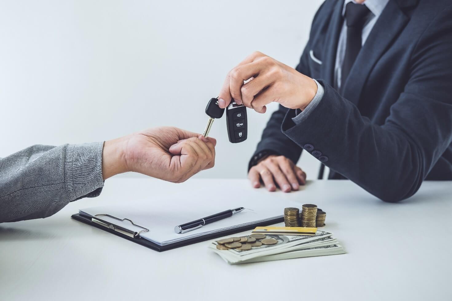Man giving car keys to another man after a transaction
